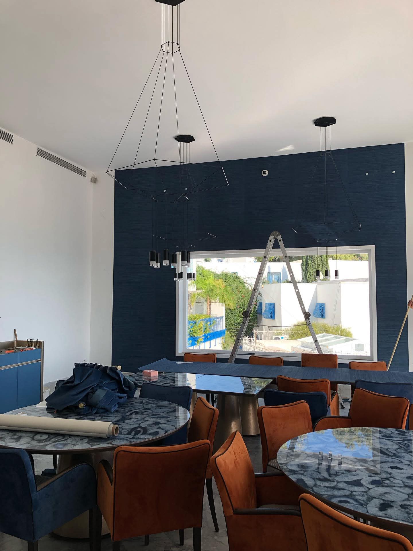 Salle à manger contemporaine — mur texturé bleu marine et suspensions graphiques