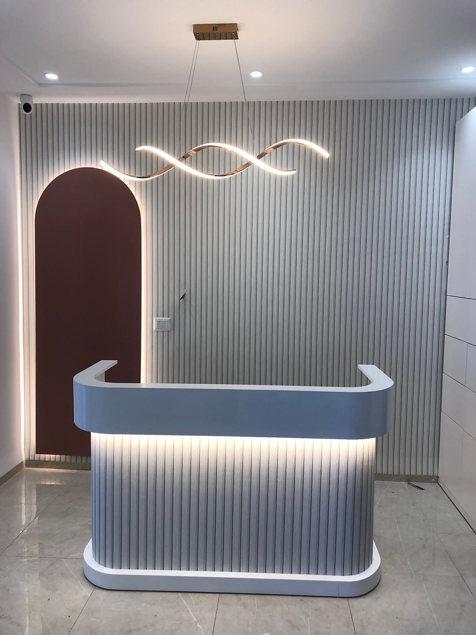 Comptoir d'accueil — niche arrondie terracotta et rubans LED