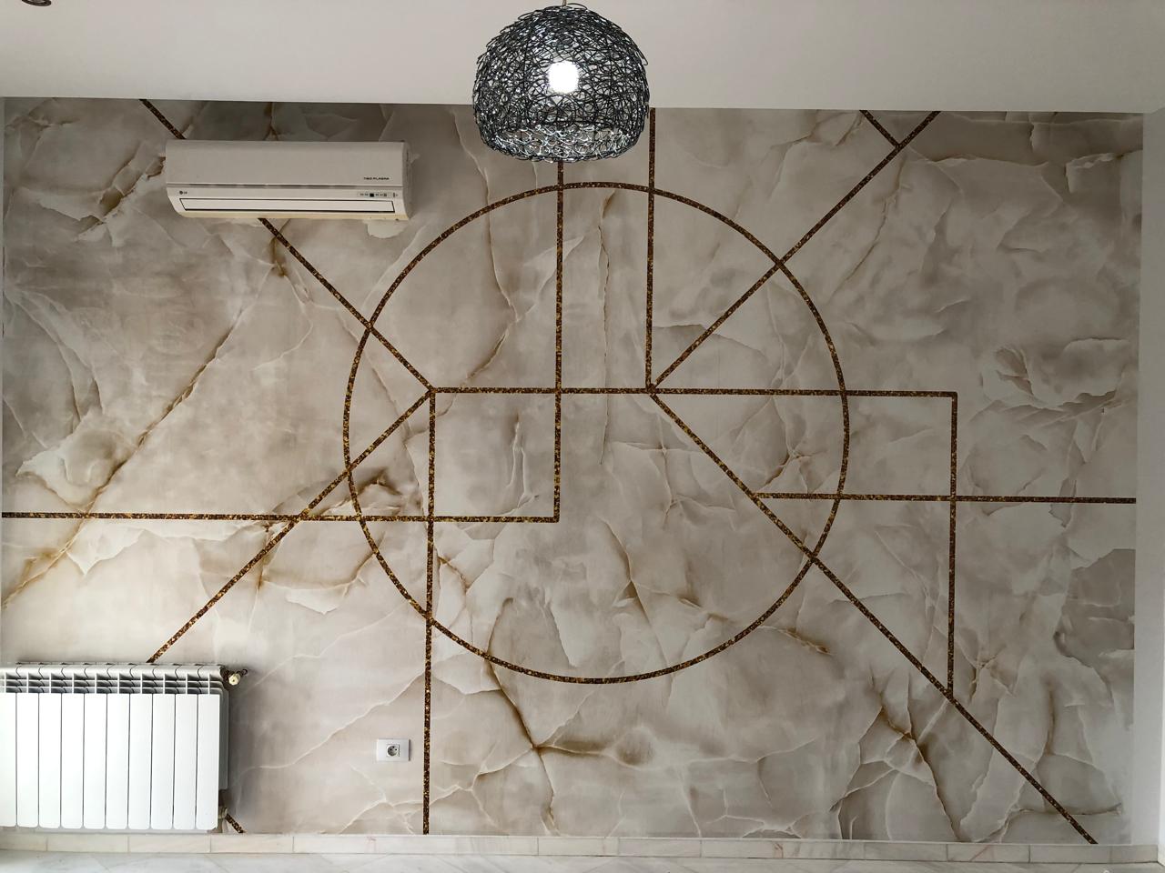 Mur effet marbre — lignes géométriques dorées et radiateur blanc
