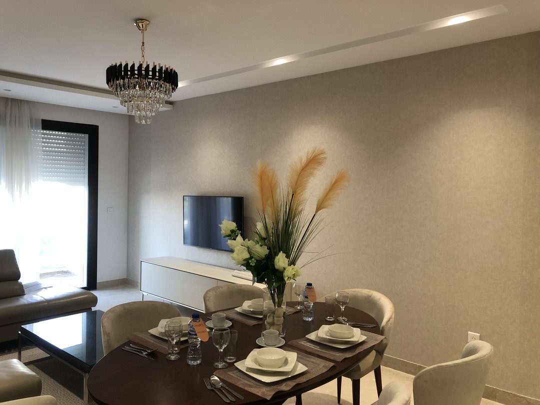 Pièce à vivre lumineuse — table dressée, suspension cristal et bouquet de pampas